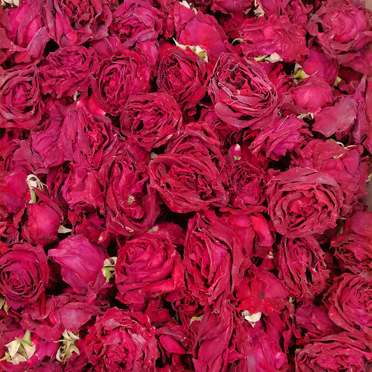 Close-up of Whole freeze-dried dark red rose crown tea blossoms with a soft focus background